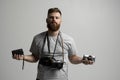 Portraite of professional handsome bearded male photographer with bunch of vintage photo cameras in photo studio