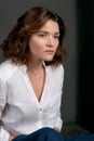 Portraite of young, beautiful sad woman actress with short brown hair in white shirt and blue pants Royalty Free Stock Photo
