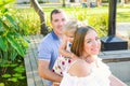 Portraits of happy family of three -mother, father and daughter having fun near pond with water lilies in the park. Family recreat Royalty Free Stock Photo