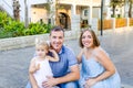 Portraits of happy family of three - pregnant mother, father and daughter having fun during walk in the city park. Family recreati Royalty Free Stock Photo