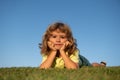 Portraits of happy kids playing and laying on grass outdoors in summer park. Funny child face outdoor.