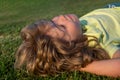 Portraits of happy kids playing and laying on grass outdoors in summer park.