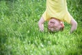 Portraits of happy kids playing upside down outdoors in summer park. Royalty Free Stock Photo