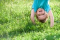 Portraits of happy kids playing upside down outdoors in summer park. Royalty Free Stock Photo