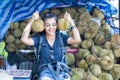 Portraits young asian woman hand holding durian and sitting on the car in the street market, Thailand