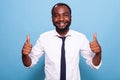 Portratit of smiling optimistic person in white shirt giving two thumbs up Royalty Free Stock Photo