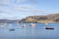Small harbor with fishing boats anchored in the calm waters of Loch Portree, Portree, Isle of Skye, Scotland, UK