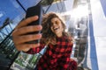 Portret of laughing girl making selfie with smart phone outdoors on the city street. Royalty Free Stock Photo