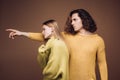 Portret of stylish confident male and female models with nature hairstyle wearing a yellow and green sweater and