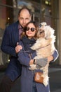 Portret of stylish young couple with shih-tzu dog in city