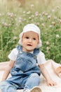 Portriat of adorable, charming toddler girl in flowers meadow. Smiling happy baby child on summer day with colorful flowers,