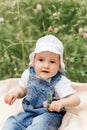 Portriat of adorable, charming toddler girl in flowers meadow. Smiling happy baby child on summer day with colorful flowers,