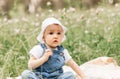 Portriat of adorable, charming toddler girl in flowers meadow. Smiling happy baby child on summer day with colorful flowers,