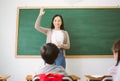 Portriat of Smiling female Asian teacher raising your hand and ask question to provide an example for students to answer in