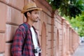 Portriat of young asian man tourist backpacker and camera standing while traveling around city in summer vacation