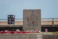 A D-day war memorial with poppy wreaths in the foreground