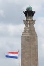 A dutch flag flying behind a British war memorial