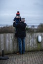 A grandfather holding his grandson up high to look at a view