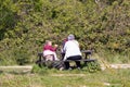 04-19-2021 Portsmouth, Hampshire, UK Grandparents sitting with their grandchild on a picnic bench in the sun eating in spring Royalty Free Stock Photo