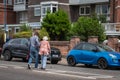 08/11/2019 Portsmouth, Hampshire, UK a man helping an elderly lady with a walking stick or cane to cross a busy road