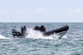 06/06/2019 Portsmouth, Hampshire, UK masked police officers in a rigid inflatable boat or RIB patrolling the shoreline with waves