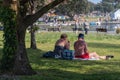 A middle aged couple sitting under a tree in a park during a warm summer day