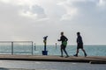 Middle aged male and female runners jogging along the promenade at the seaside