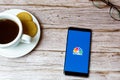 01-30-2021 Portsmouth, Hampshire, UK A Mobile phone or cell phone laid on a wooden table with a CNBC news app opening also a