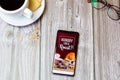 03-22-2021 Portsmouth, Hampshire, UK A mobile phone or cell phone laid on a wooden table with the Toby Carvery app open on screen Royalty Free Stock Photo