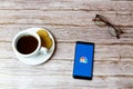 01-30-2021 Portsmouth, Hampshire, UK A Mobile phone or cell phone laid on a wooden table with a CNBC news app opening also a