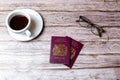 02-08-2021 Portsmouth, Hampshire, UK a pair Of British passports laid on a wooden table next to a coffee and a pair of glasses Royalty Free Stock Photo