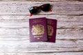 02-08-2021 Portsmouth, Hampshire, UK a pair Of British passports laid on a wooden table next to a pair of sunglasses Royalty Free Stock Photo