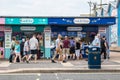 People queue for food at a seaside kiosk or fish and chips stall