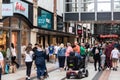 Shoppers walking past shop windows at a busy shopping centre