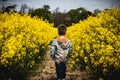 A small boy walking through a field full of bright yellow oil seed rape flowers Royalty Free Stock Photo
