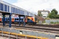 A southern rail train passing under a footbridge