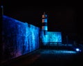 Southsea castle and lighthouse lit up by blue flood lights at night