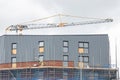 A tower block under construction with builders working on scaffolding