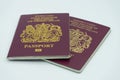 04/23/2020 Portsmouth, Hampshire, UK Two maroon British passports isolated on a white background Royalty Free Stock Photo