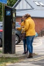 06/06/2019 Portsmouth, Hampshire, UK two women using a parking meter to pay to park Royalty Free Stock Photo