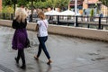 Two women walking together in the rain without umbrellas