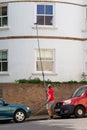 09/29/2020 Portsmouth, Hampshire, UK A window cleaner using a telescopic brush to clean windows that are at a height