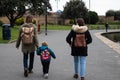 A young family walking together wearing backpacks