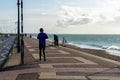 10/09/2019 Portsmouth, Hampshire, UK A young man running alone on the promenade of a british beach