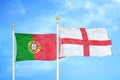 Portugal and England two flags on flagpoles and blue sky