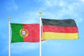 Portugal and Germany two flags on flagpoles and blue sky