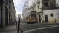 Portugal, Lisbon - July 17, 2022: Trams passing through narrow streets of European city. Action. Trams traveling through