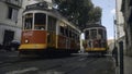 Portugal, Lisbon - July 17, 2022: Trams passing through narrow streets of European city. Action. Trams traveling through