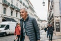 An elderly tired man is a local resident walking down the street in Lisbon in Portugal