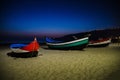 Portugal, Nazare beach, colored wooden boats on the beach at night